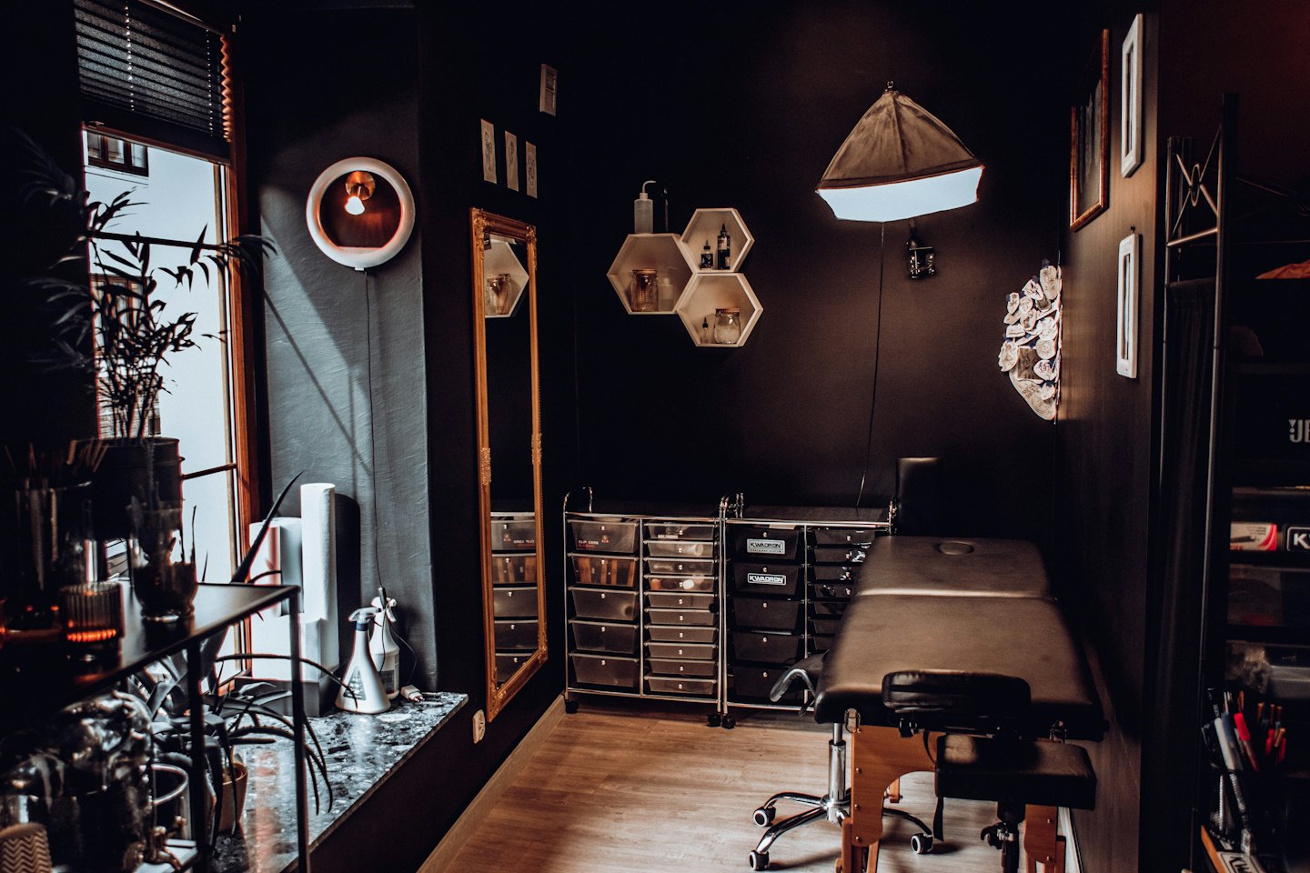 Studio di tatuaggi con lettino regolabile e carrelli per forniture.